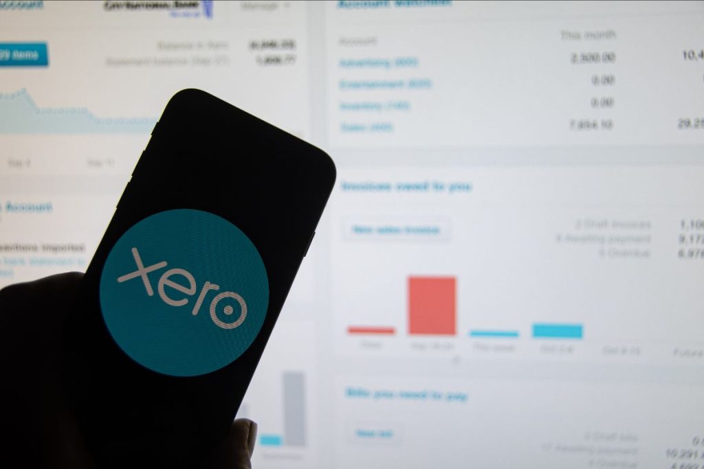 Xero displayed on a smartphone and desktop screen in background